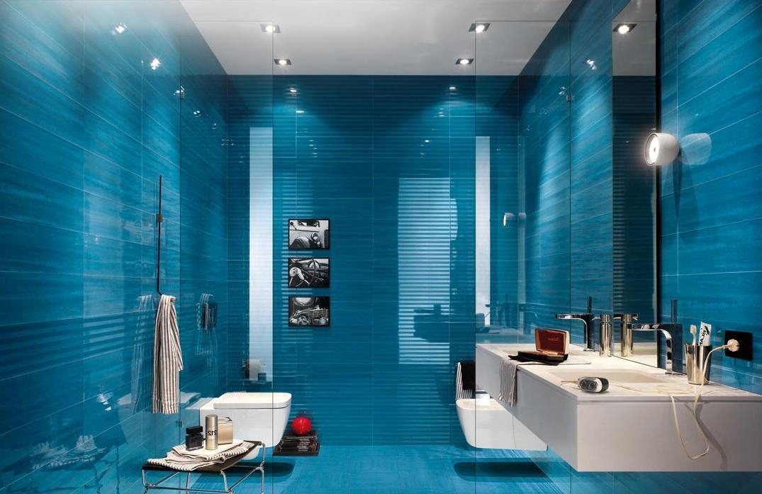دکوراسیون حمام و سرویس بهداشتی مدرن با سرامیک های آبی که رنگ ثانویه و توالت فرنگی و روشویی سفید دارد